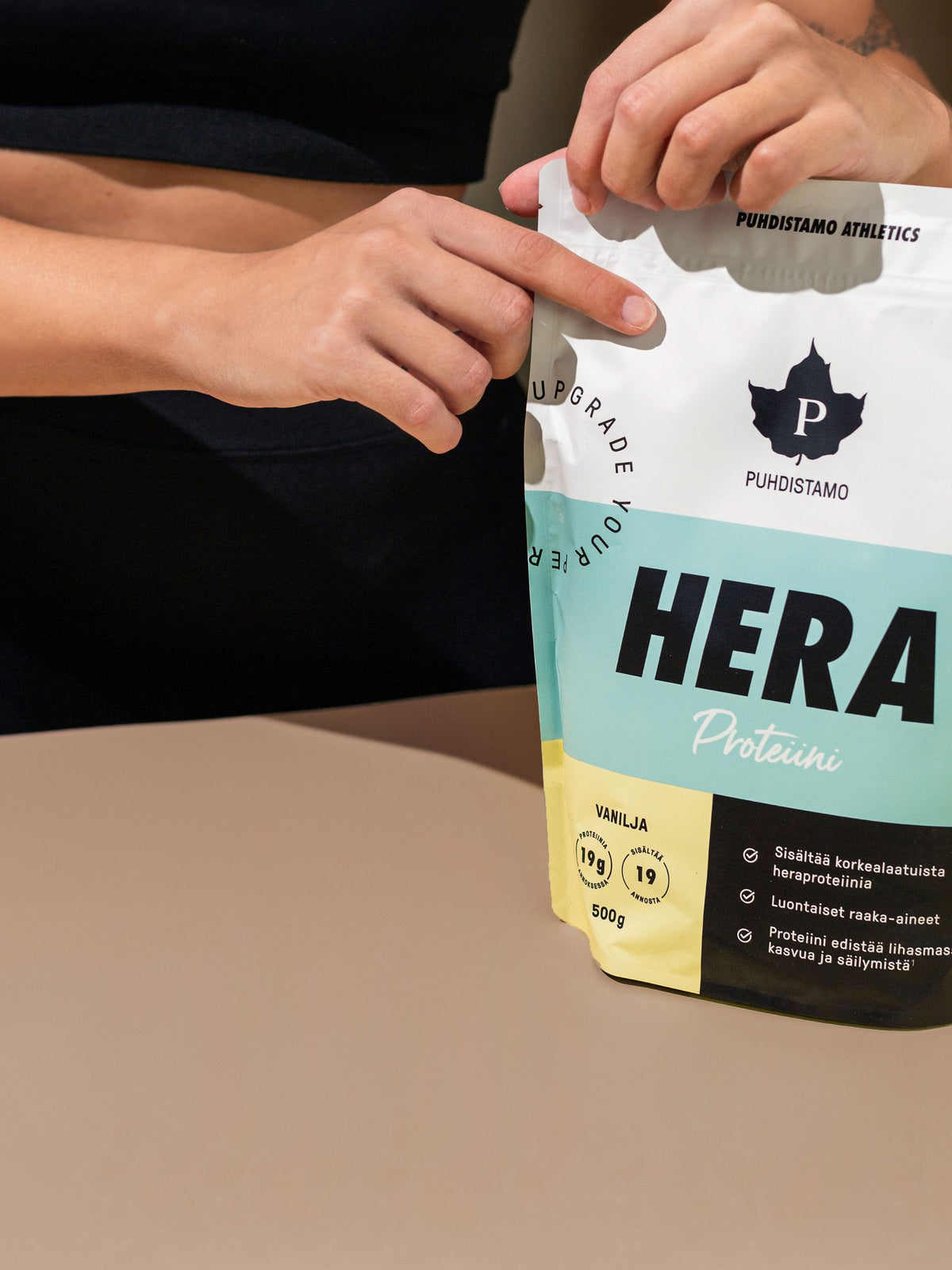 Nainen avaa Puhdistamon Heraproteiini Vanilja-pussia