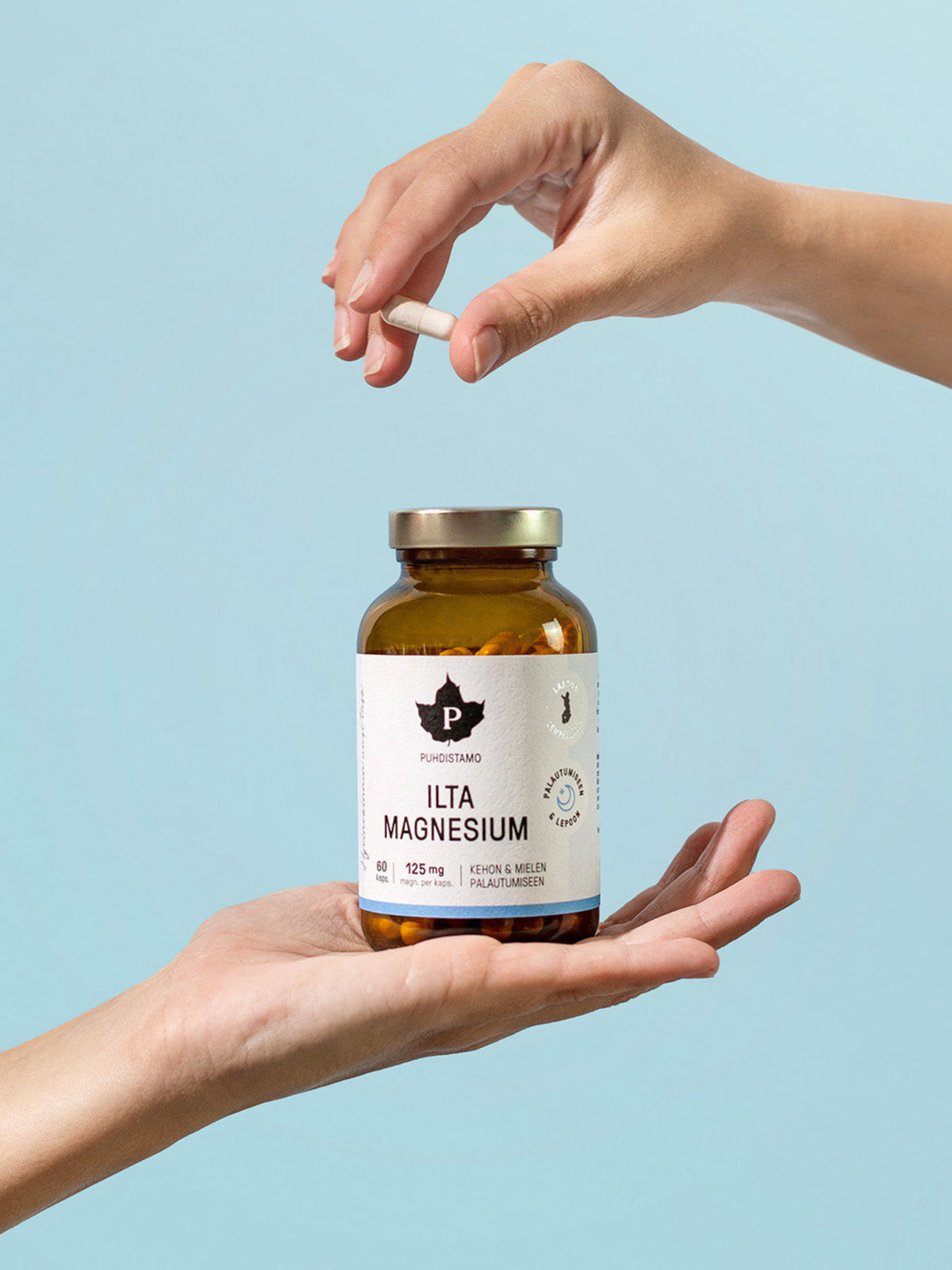 Nainen pitelee käsissään Puhdistamon Ilta Magnesium 60 kapselin purkkia