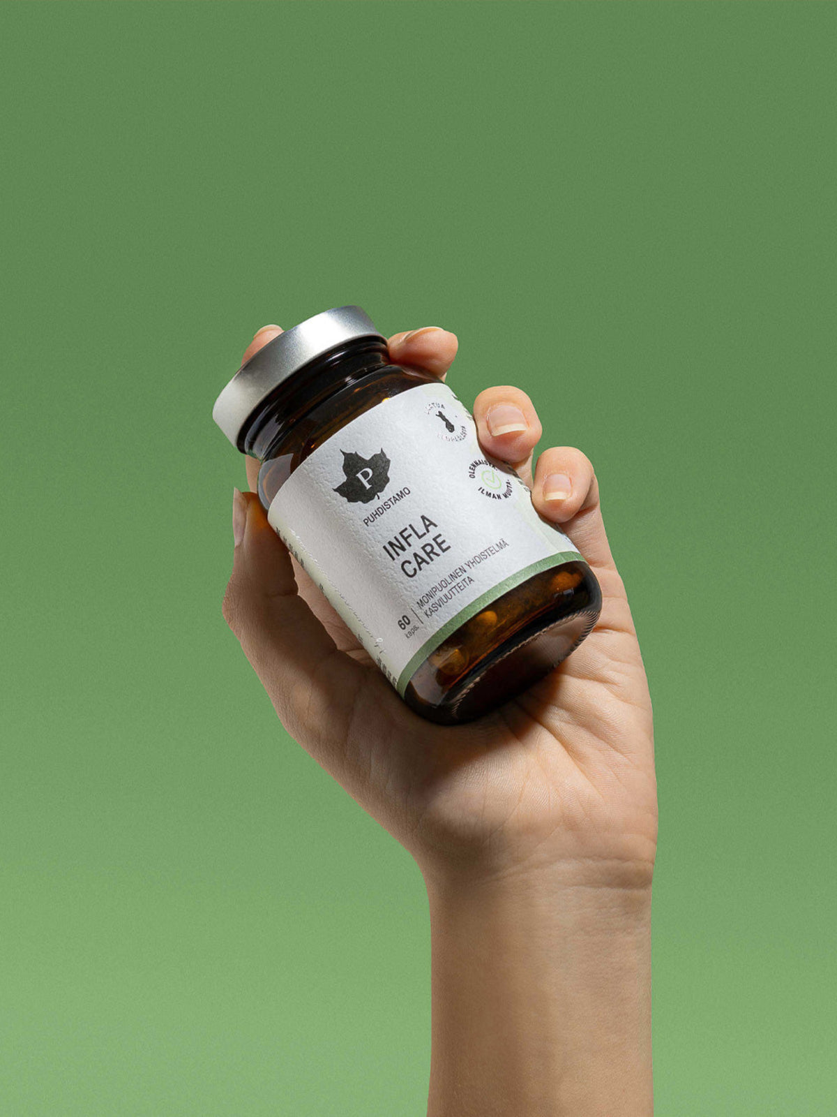 Nainen pitelee käsissään Puhdistamon Infla Care 60 kapselin purkkia