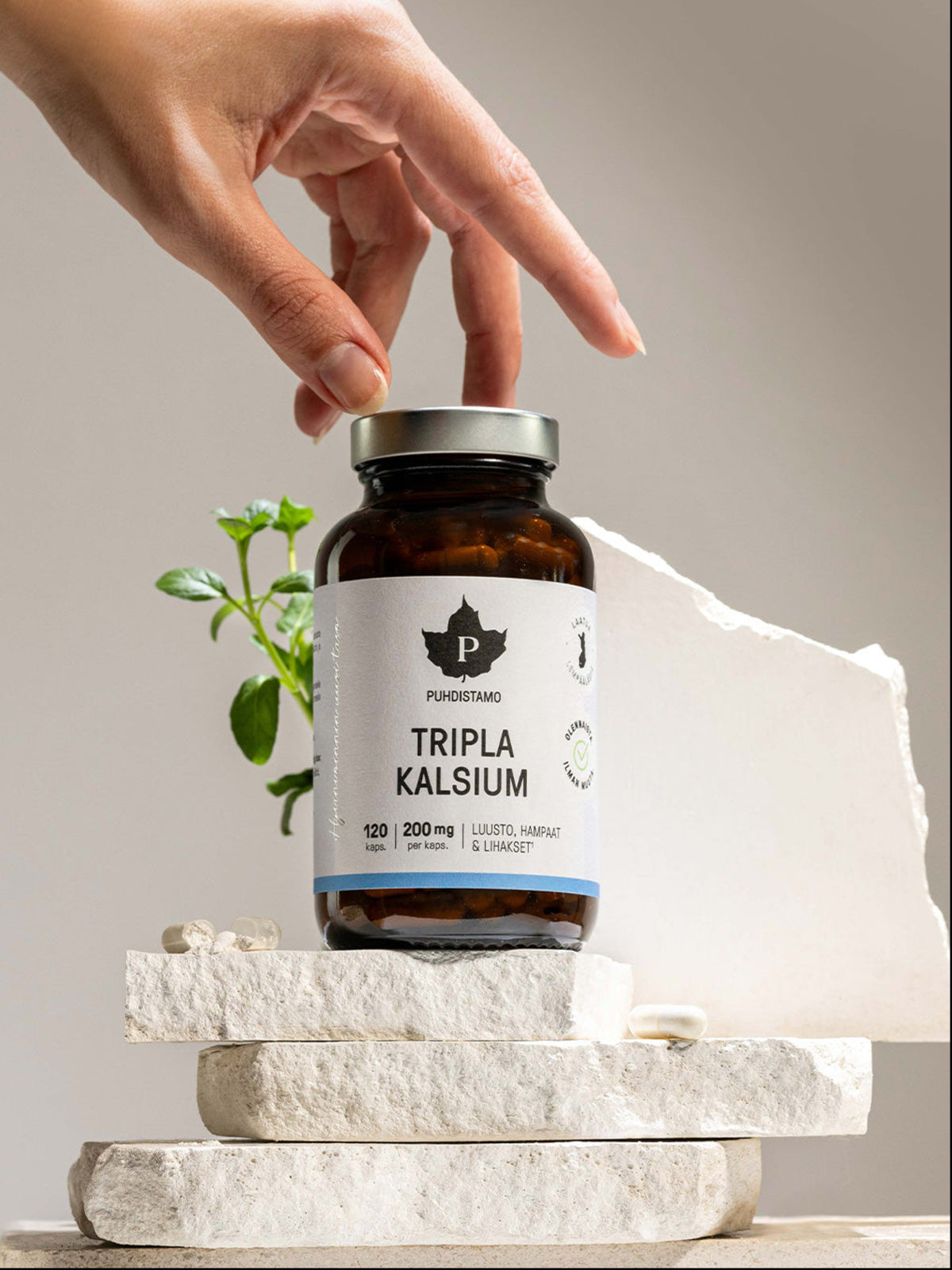 Nainen nostaa Puhdistamon Tripla Kalsium purkin kivitasolta