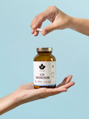 Nainen pitelee käsissään Puhdistamon Ilta Magnesium 60 kapselin purkkia