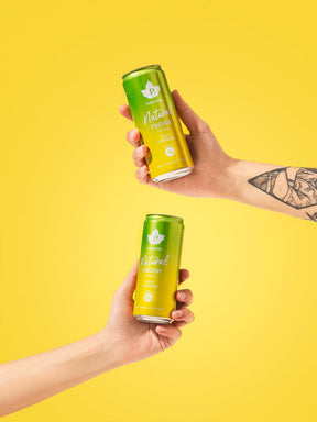 Kaksi kättä pitelee Puhdistamon Natural Energy Drink Pear Lemonade tölkkejä