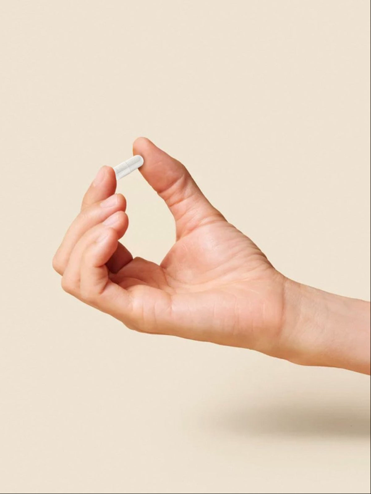 Puhdistamon kapseli kädessä