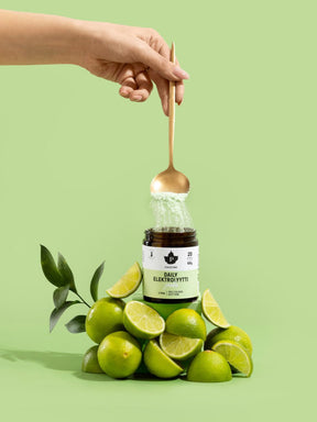 Nainen ottaa lusikalla purkista Daily Elektrolyyttijauhe Limeä