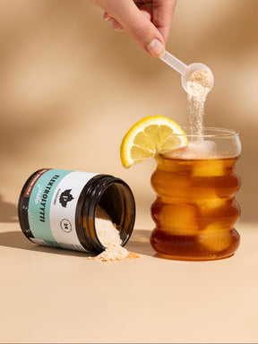 Nainen kaataa lasiin Puhdistamon Elektrolyyttijauhetta Sitruuna-Cola