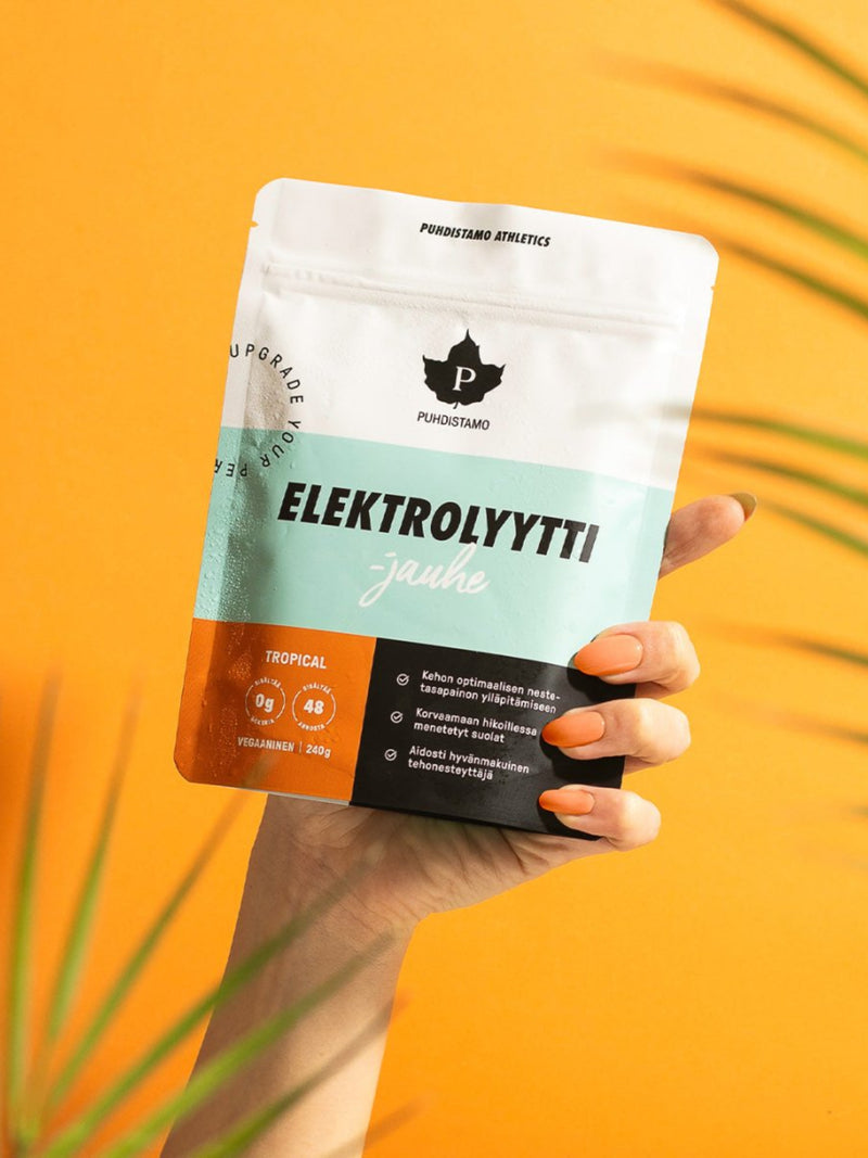 Nainen pitelee kädessään Puhdistamon Elektrolyyttijauhe Tropical -pussia