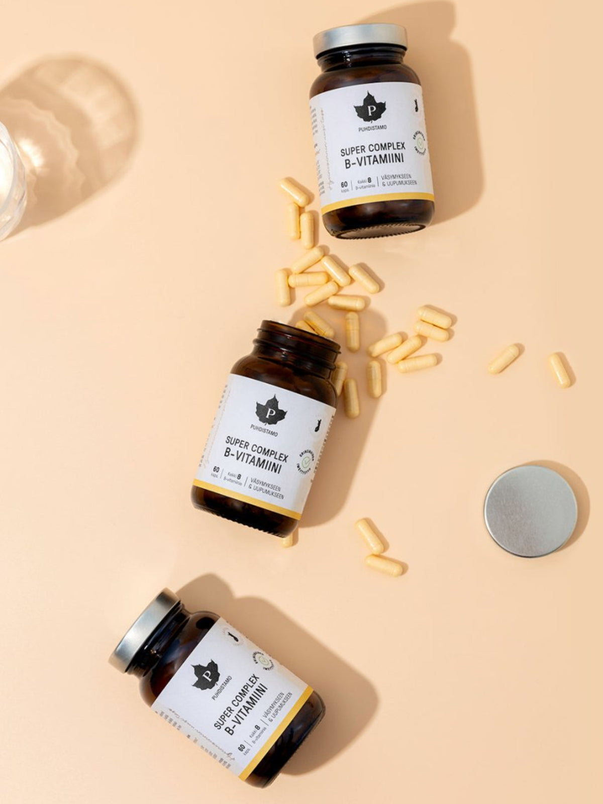 Puhdistamon Super Complex B - vitamiini purkkeja ja kapseleita vaaleaa taustaa vasten
