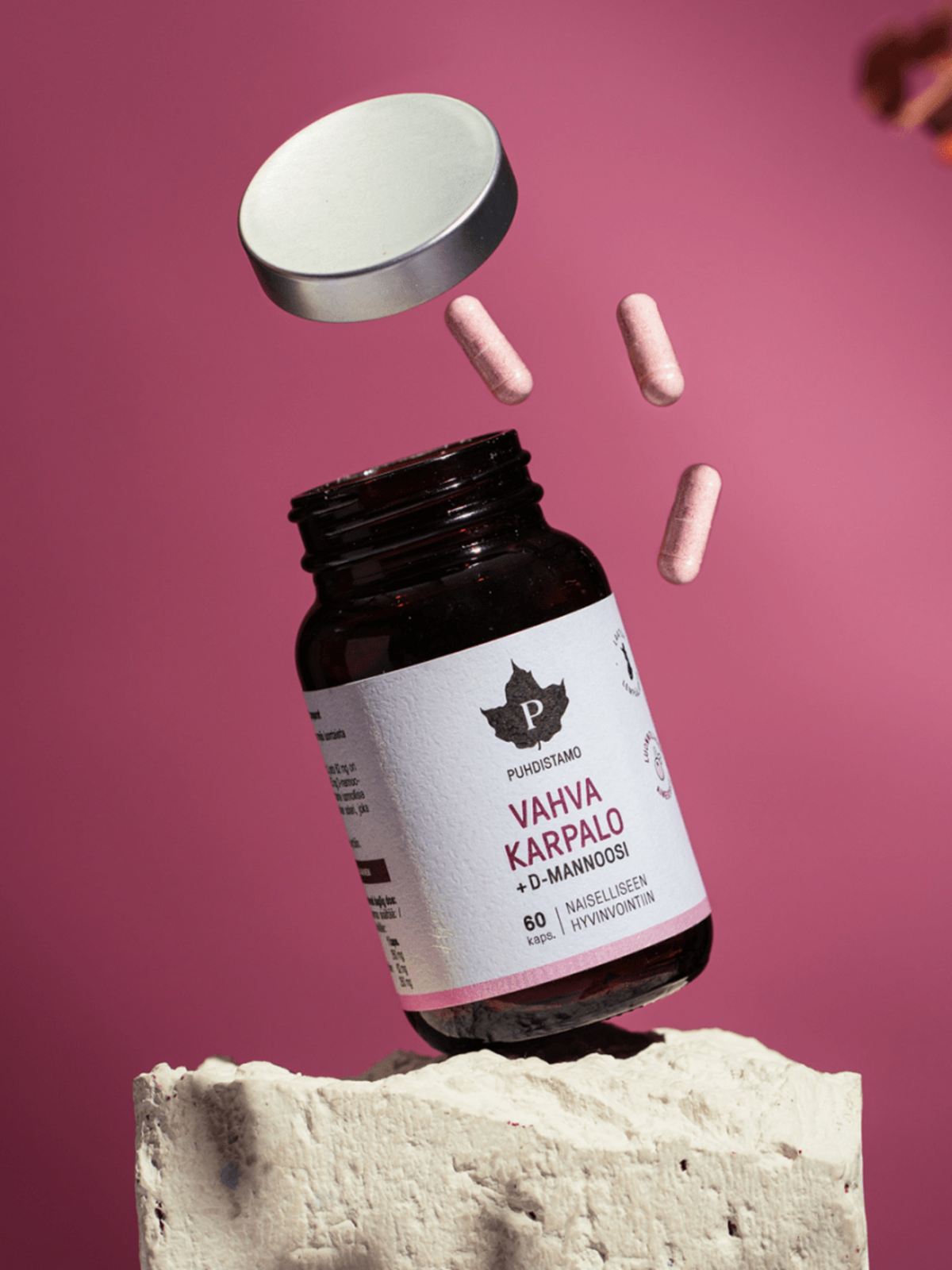 Puhdistamon Vahva Karpalo + D - mannoosi  purkki pinkkiä taustaa vasten